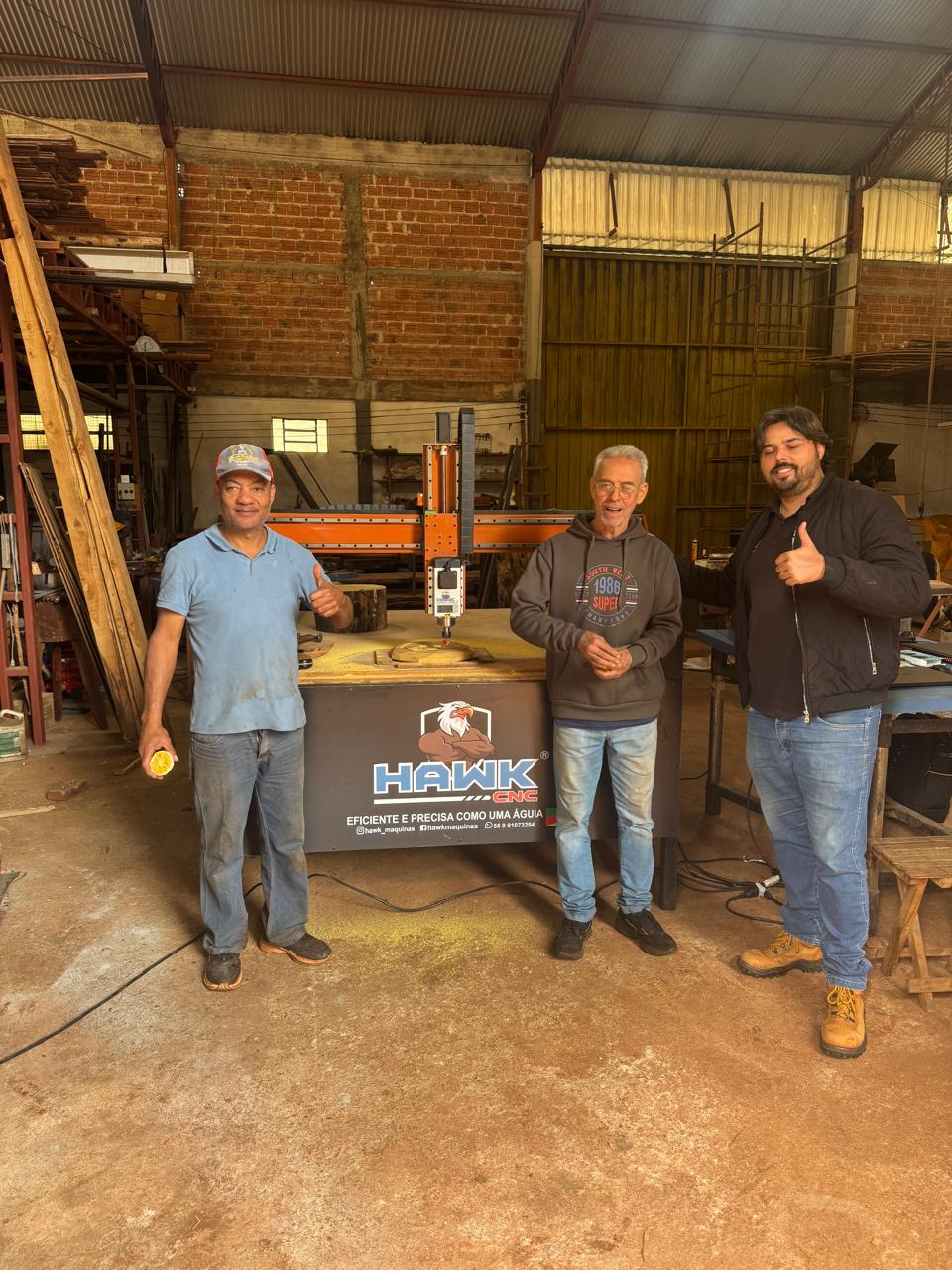 Clientes ao lado da máquina Hawk CNC entregue